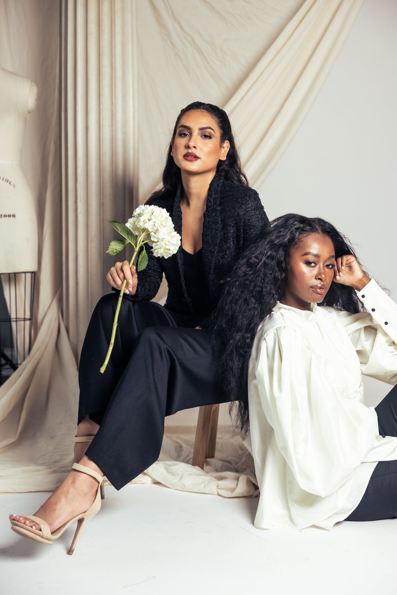 Two women in evening separates in a studio setting