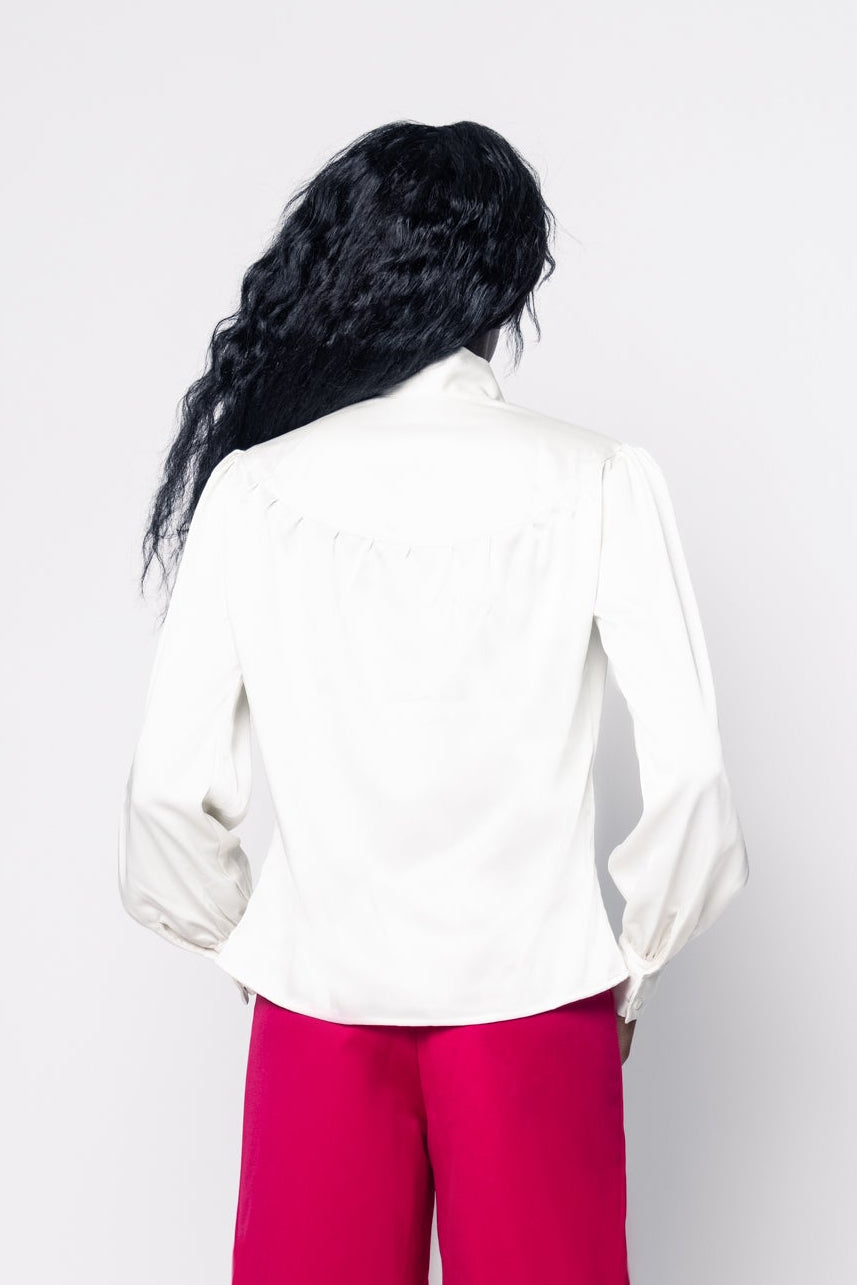 Person wearing a white top and red pants on a white background