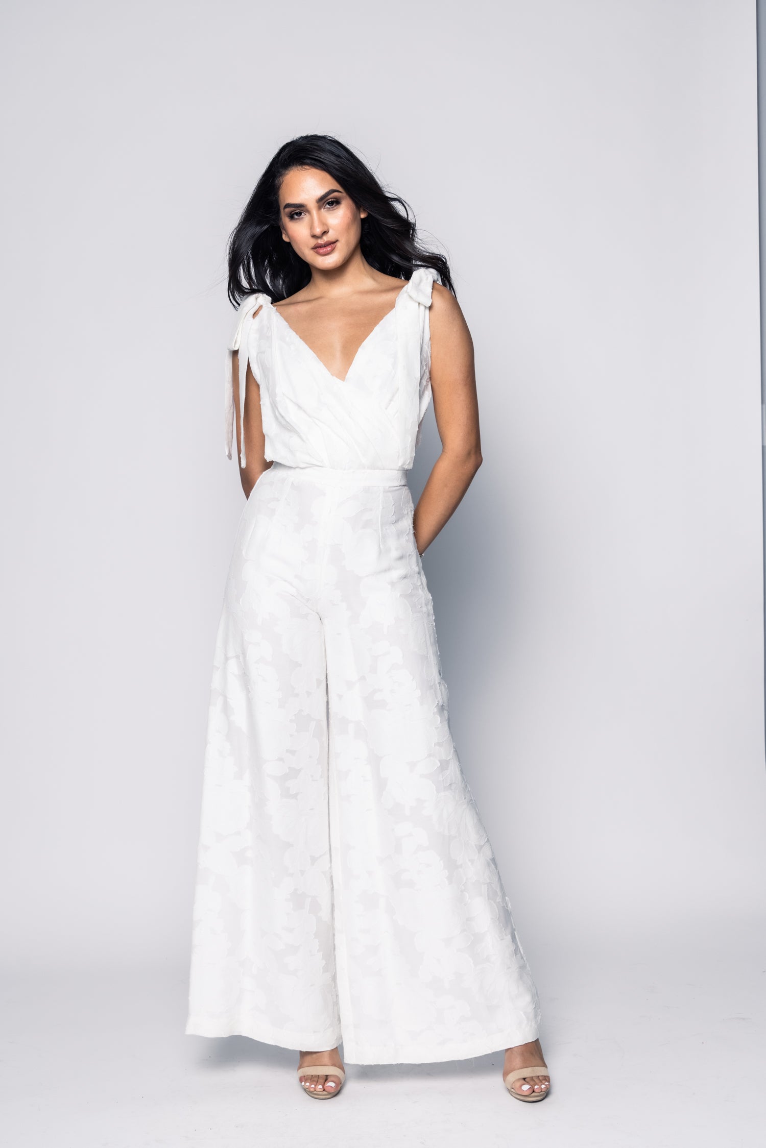 Woman wearing a white dress against a gray background