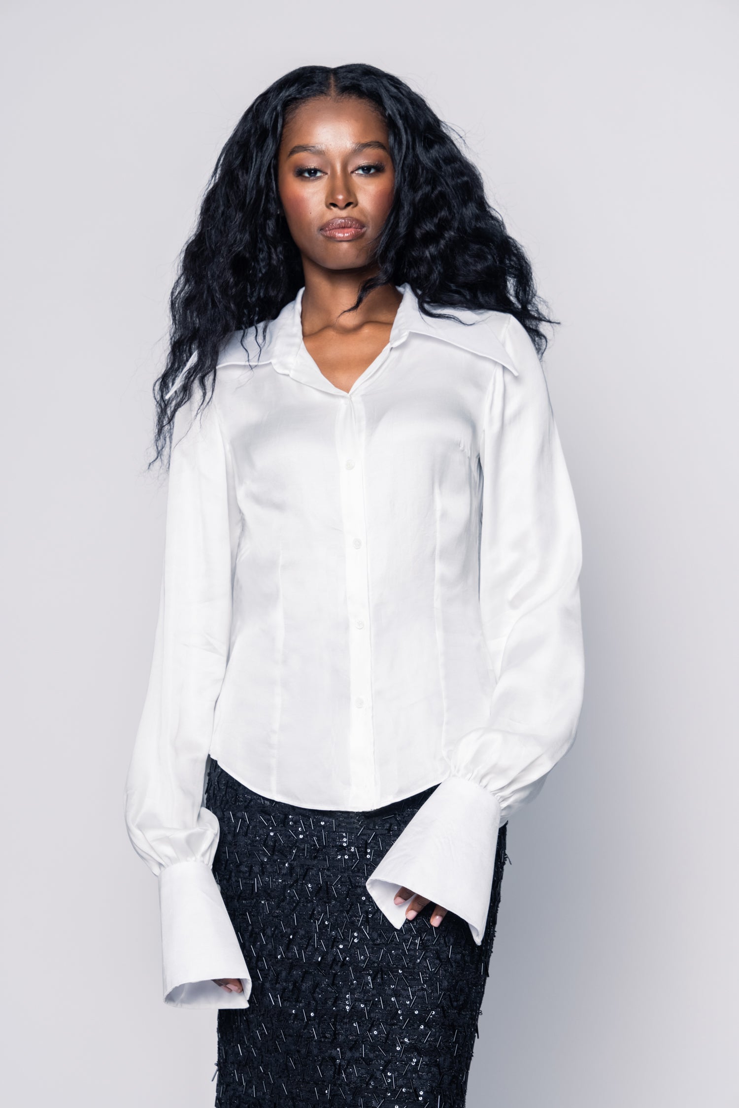 Woman wearing a white shirt against a plain background