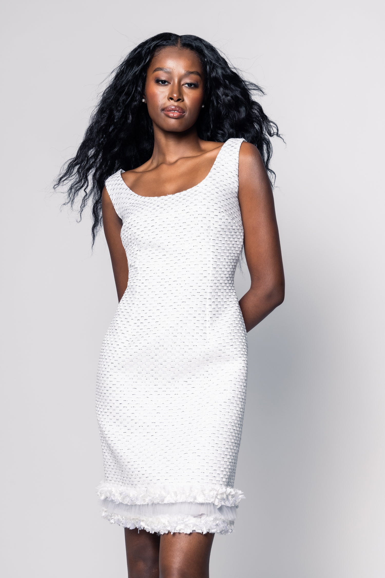 Woman wearing a white dress against a gray background