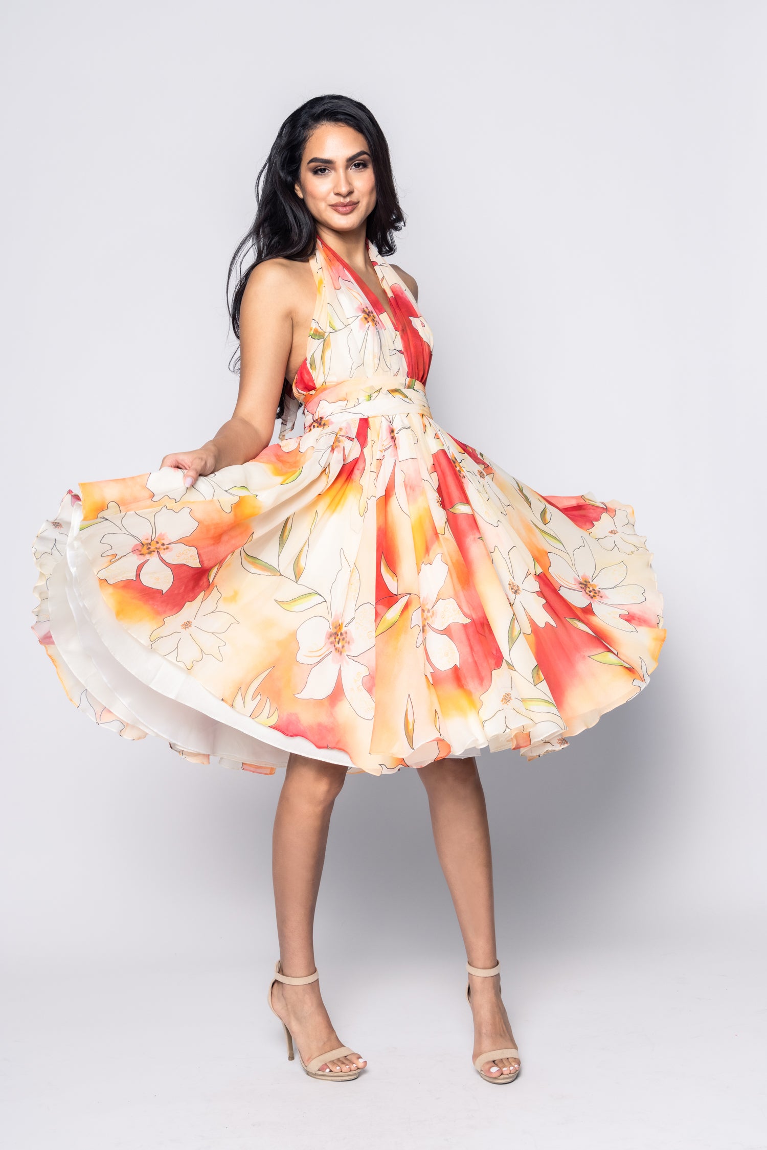 Woman wearing a colorful floral dress on a white background