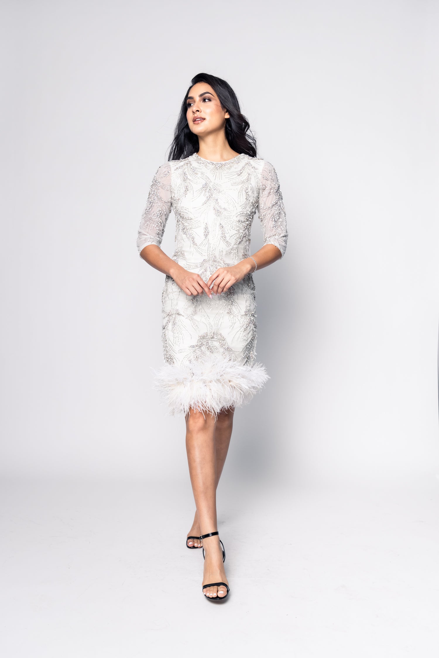 Woman wearing a white lace dress on a plain background