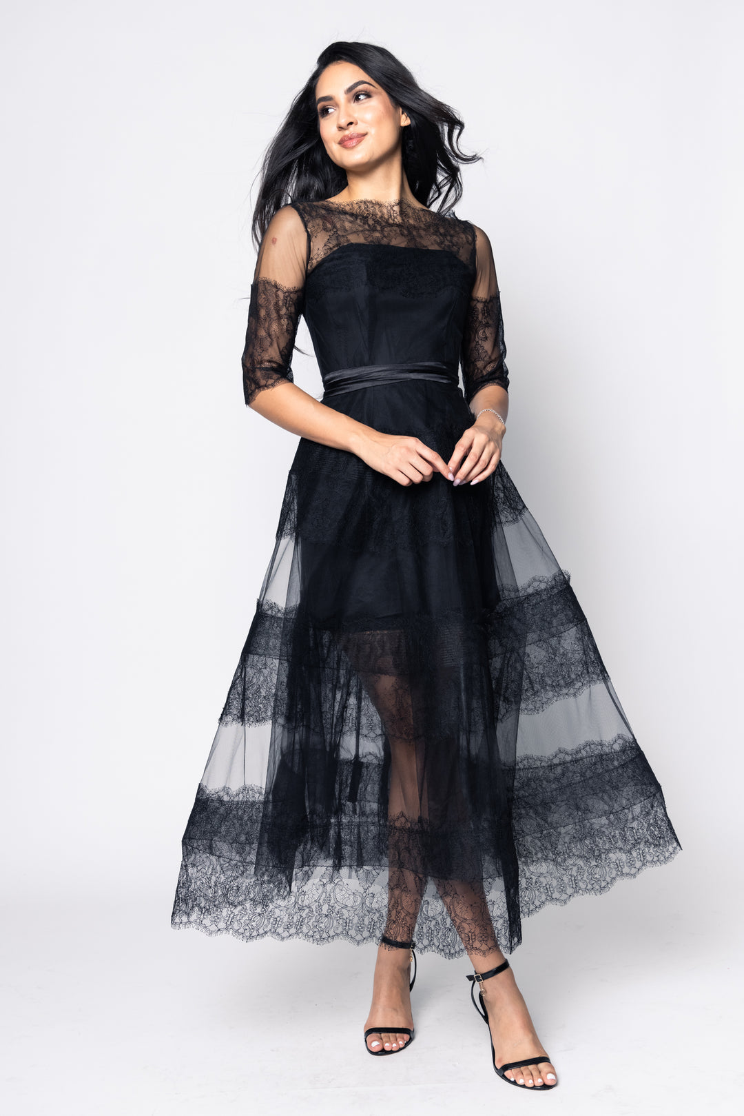 Woman wearing a black lace dress on a white background