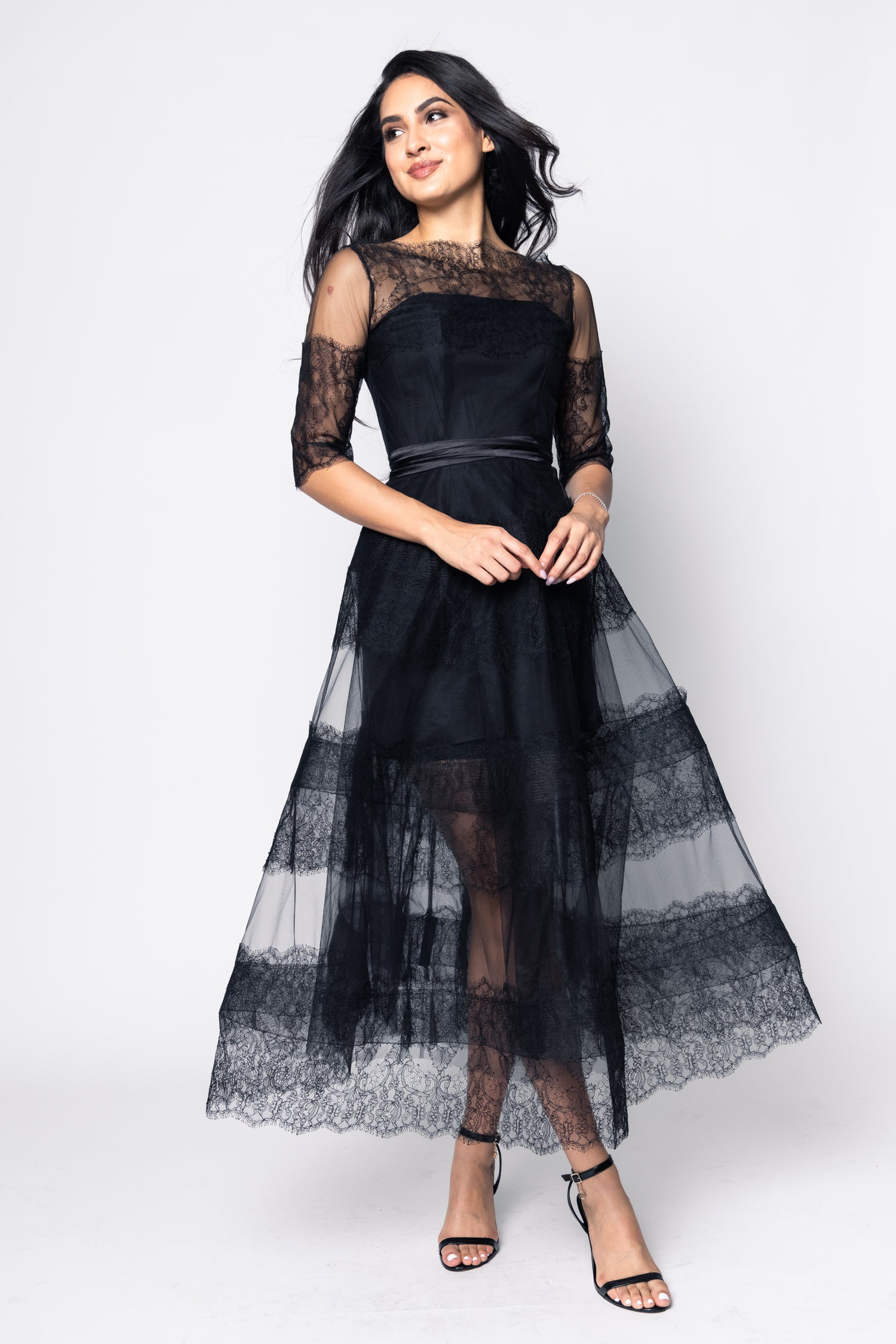 Woman wearing a black lace dress on a white background