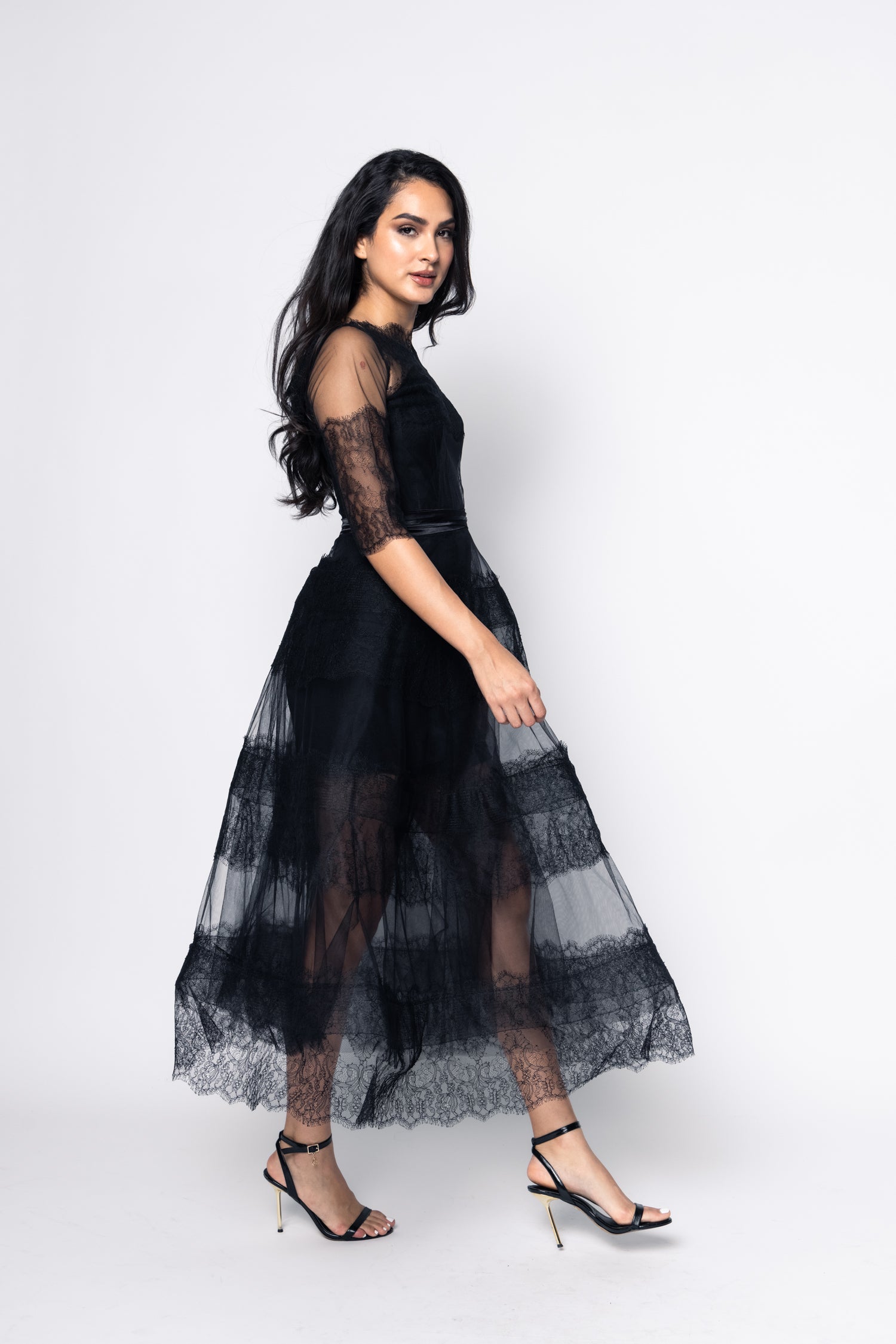 Woman wearing a black lace dress on a white background