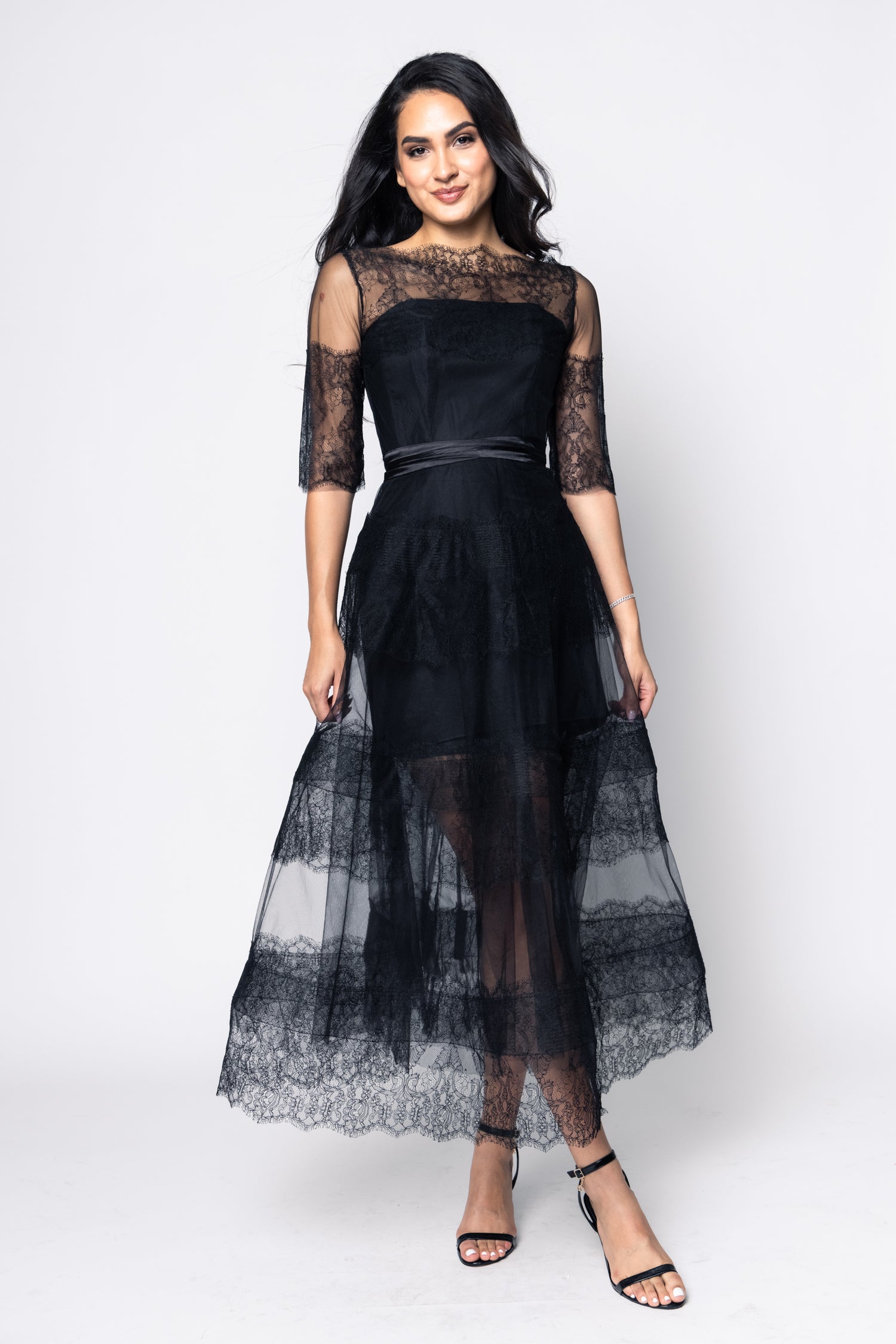 Woman wearing a black lace dress on a white background