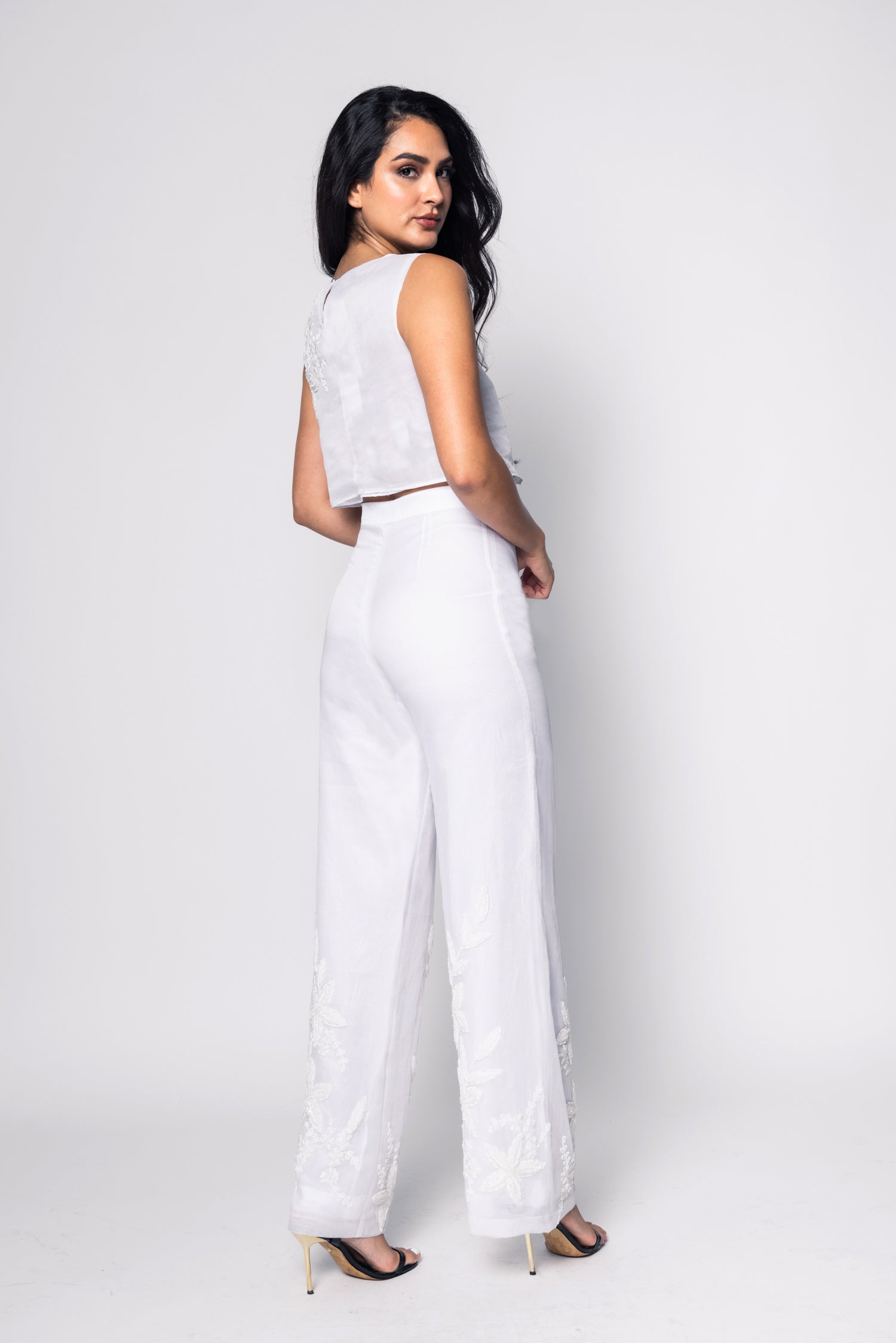 Woman wearing a white outfit against a plain background