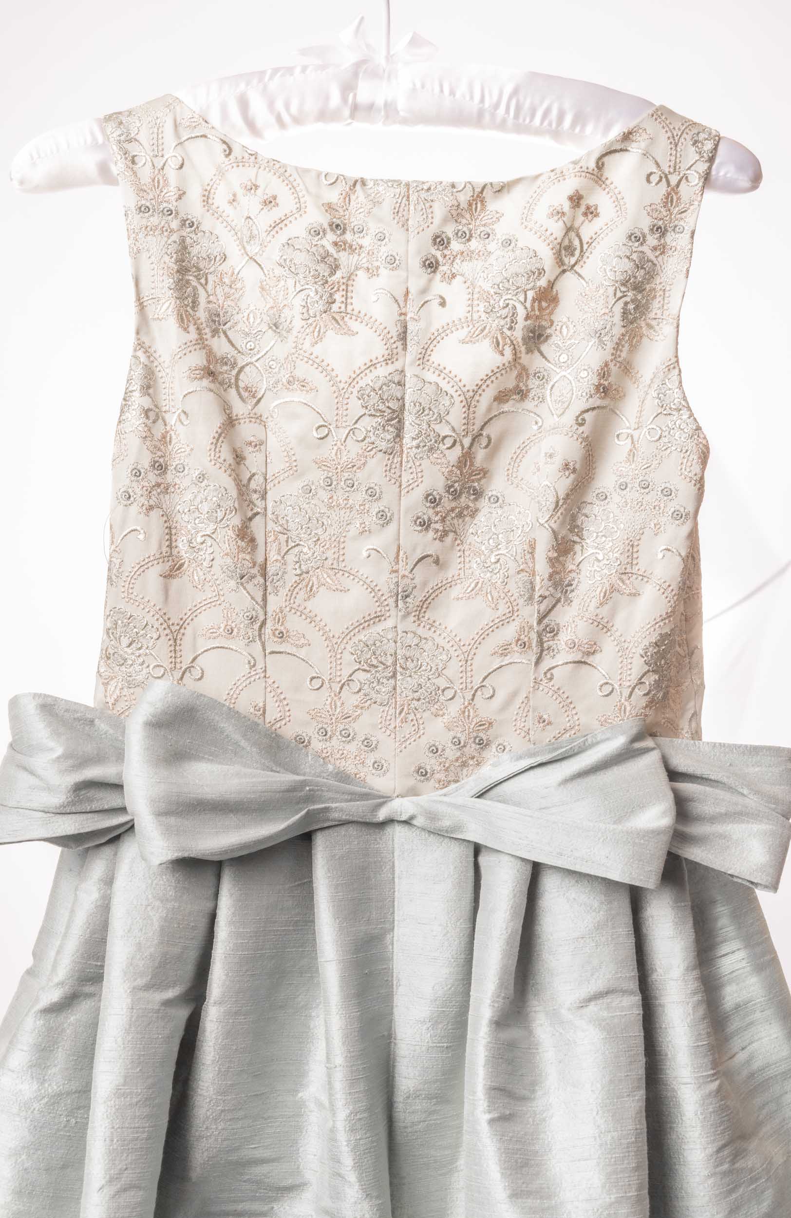 Back of an embroidered, ornate Sujata Gazder gown with large blue bow train