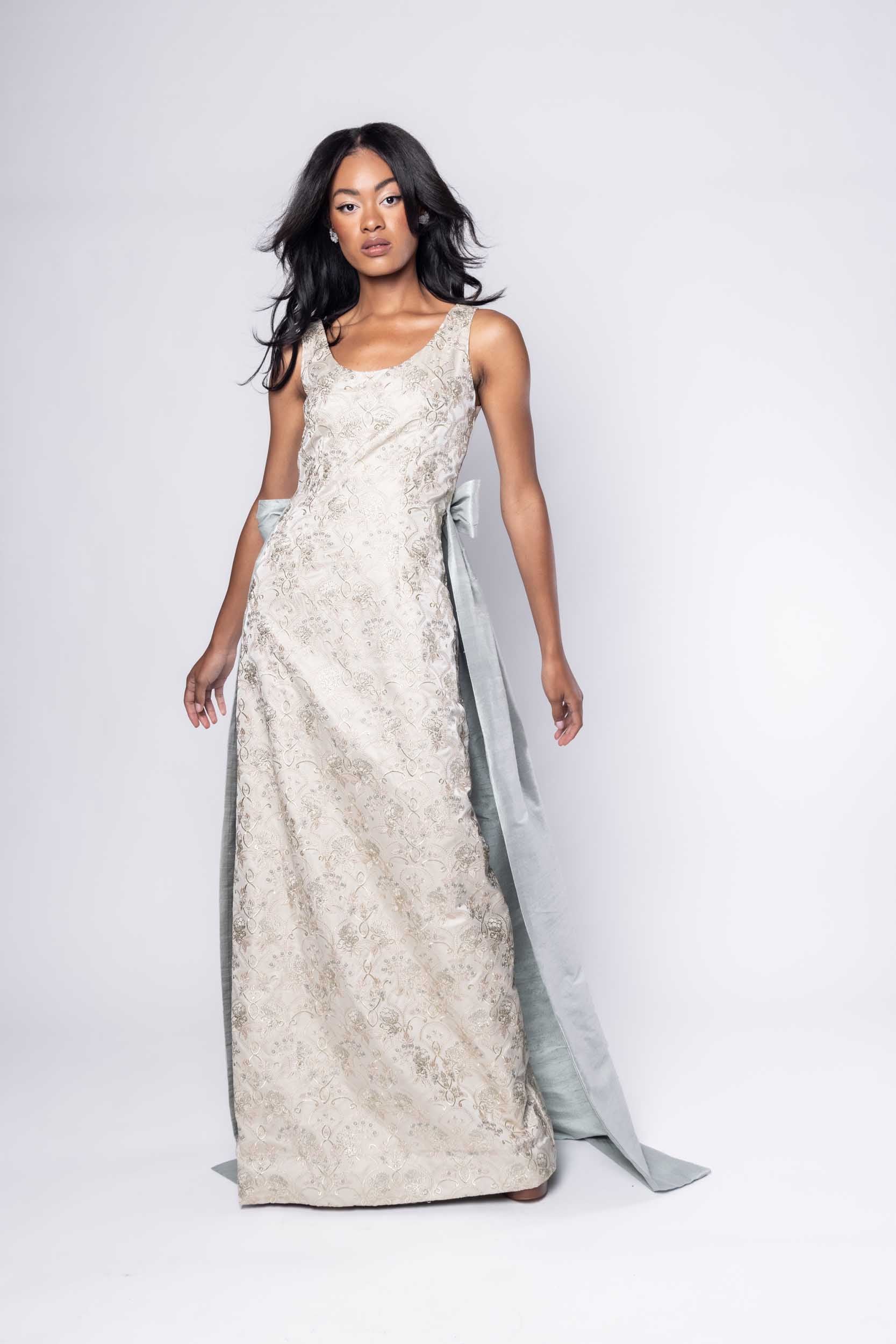 Beautiful model in an embroidered, ornate Sujata Gazder gown with large blue bow train - front view movement