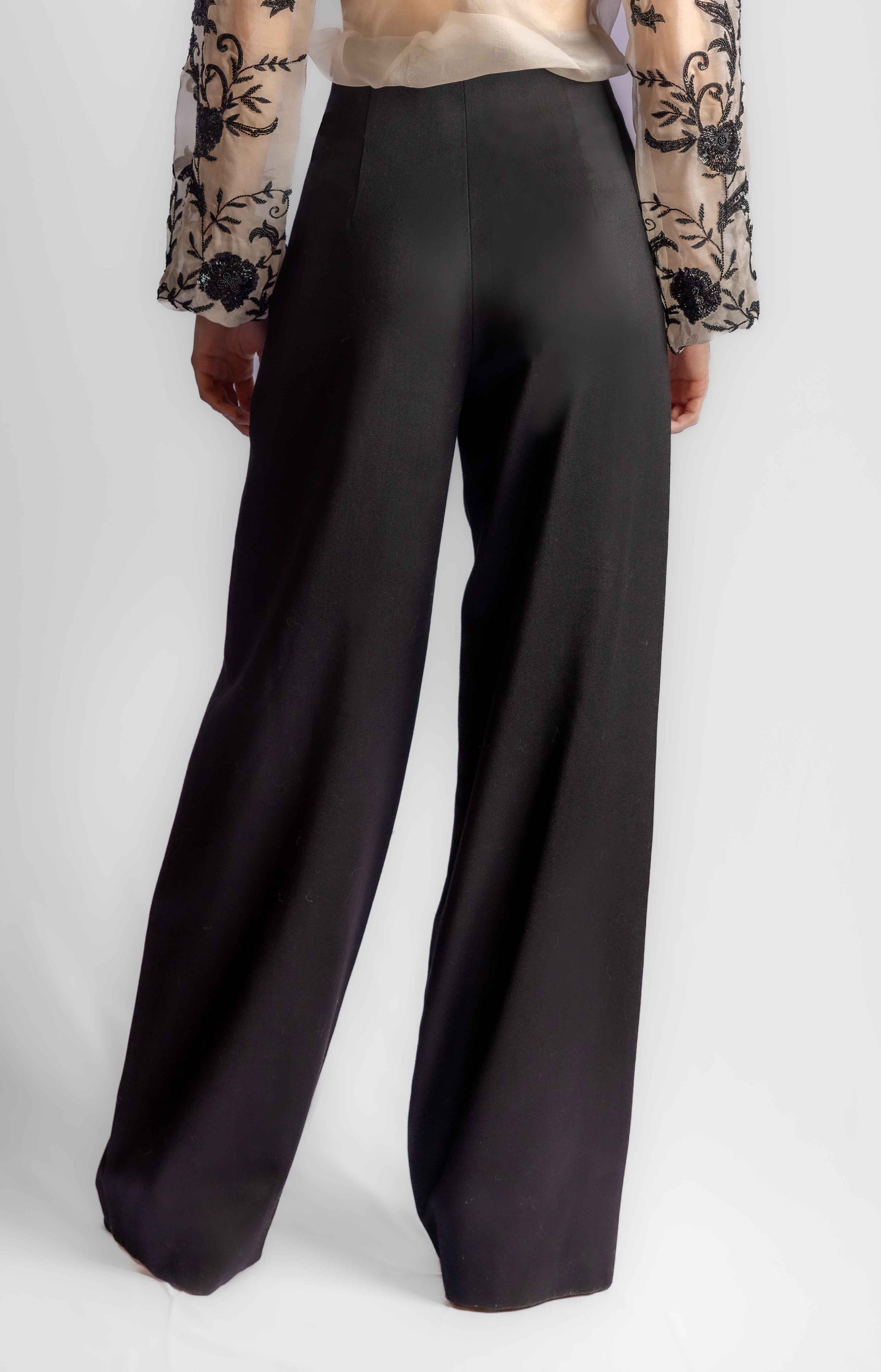 Black wide-leg pants worn by a person on a white background