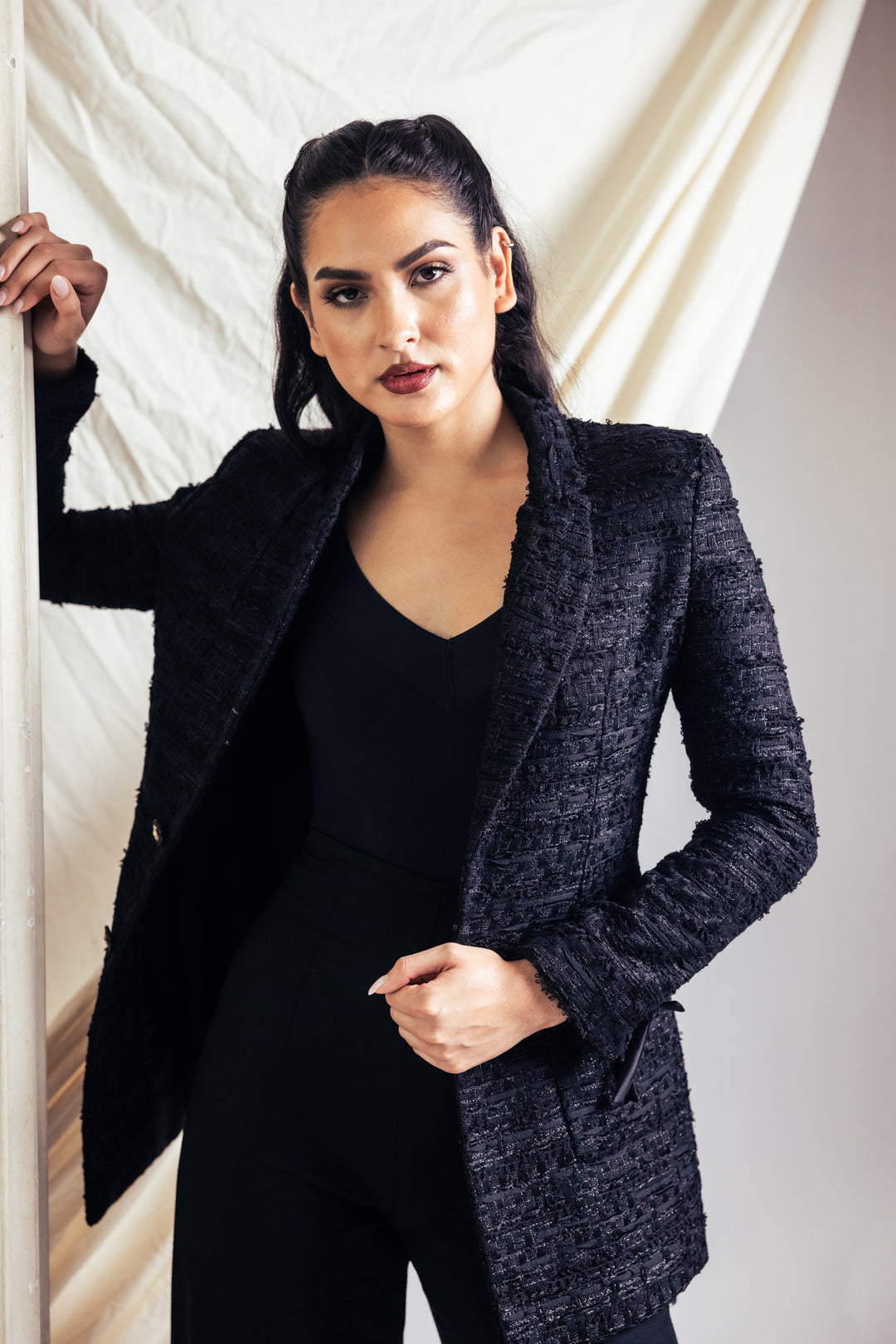 Woman in black separates in a studio setting