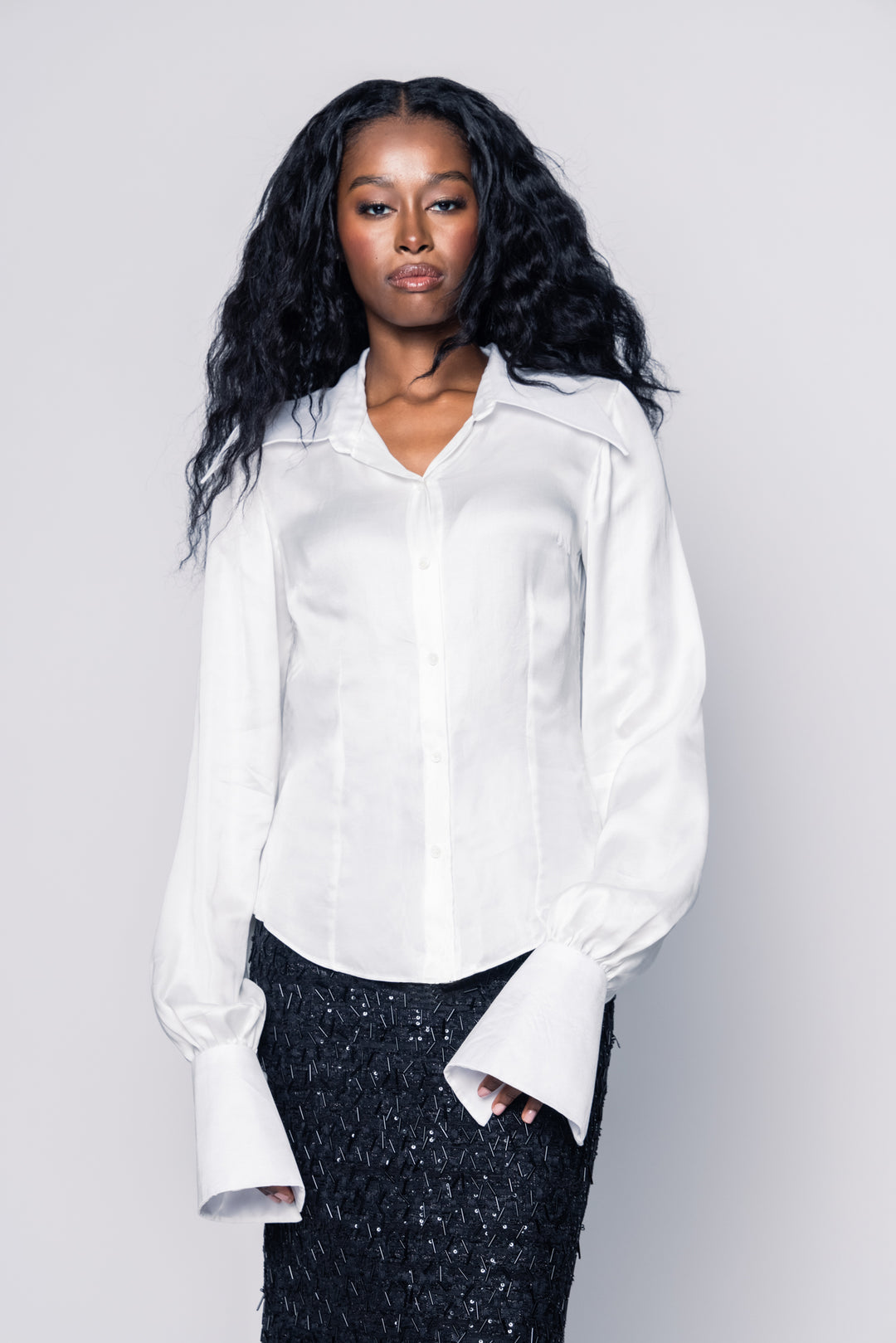 Woman wearing a white shirt against a plain background