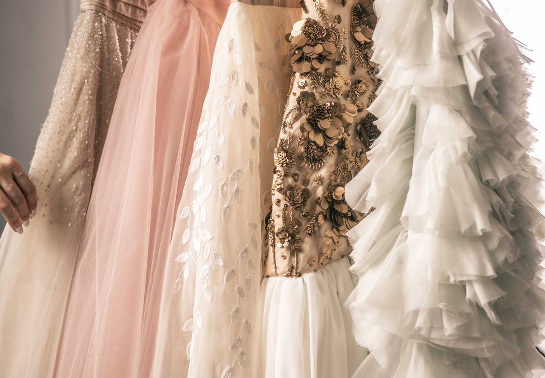 A clothing rack of beautiful pastel and ornate Sujata Gazder gowns and cocktail dresses