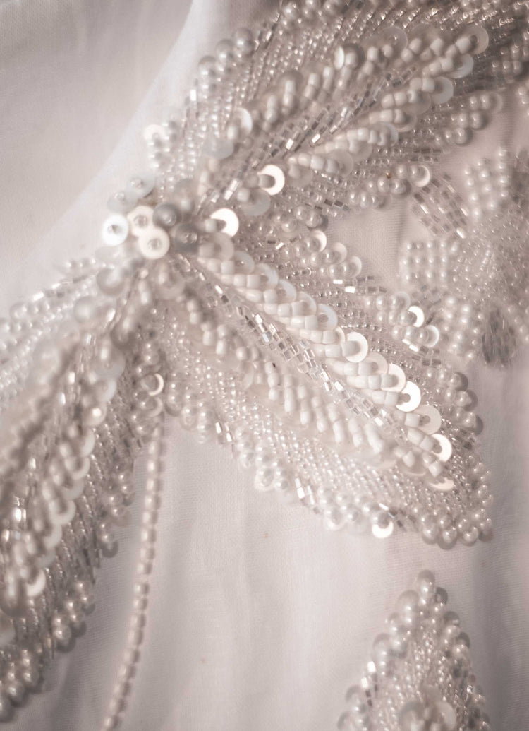 Close image of beautiful white beading and sequins on gorgeous fabric