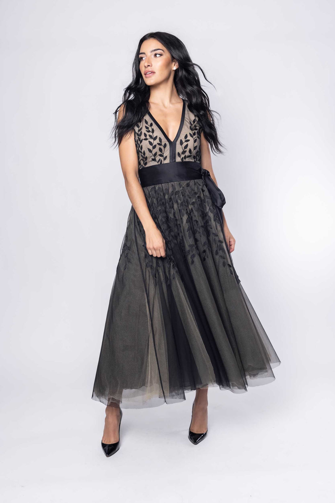 Beautiful model in an ornate black tea-length Sujata Gazder dress - front view movement