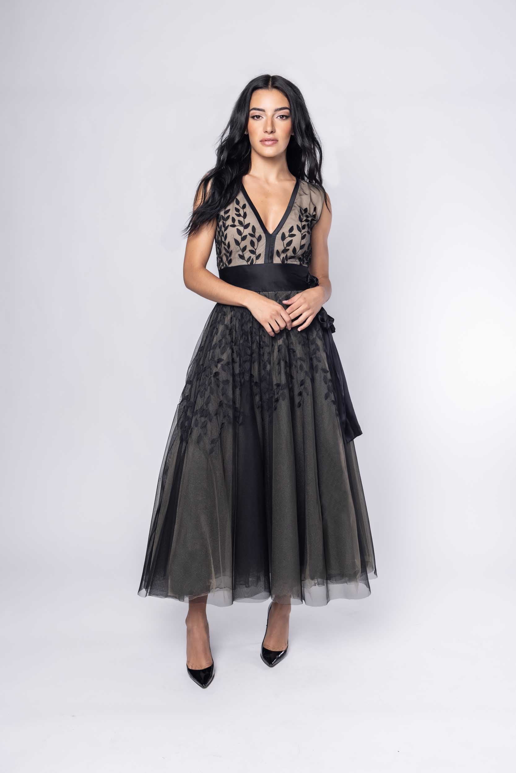 Beautiful model in an ornate black tea-length Sujata Gazder dress - front view