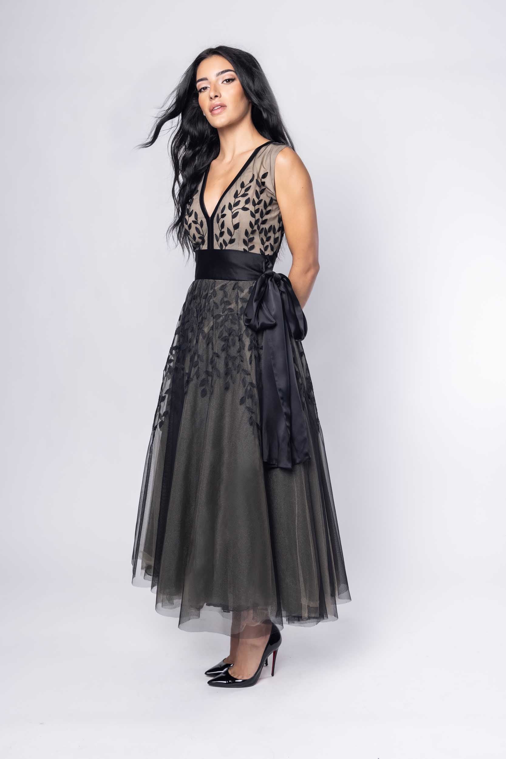 Beautiful model in an ornate black tea-length Sujata Gazder dress - side view