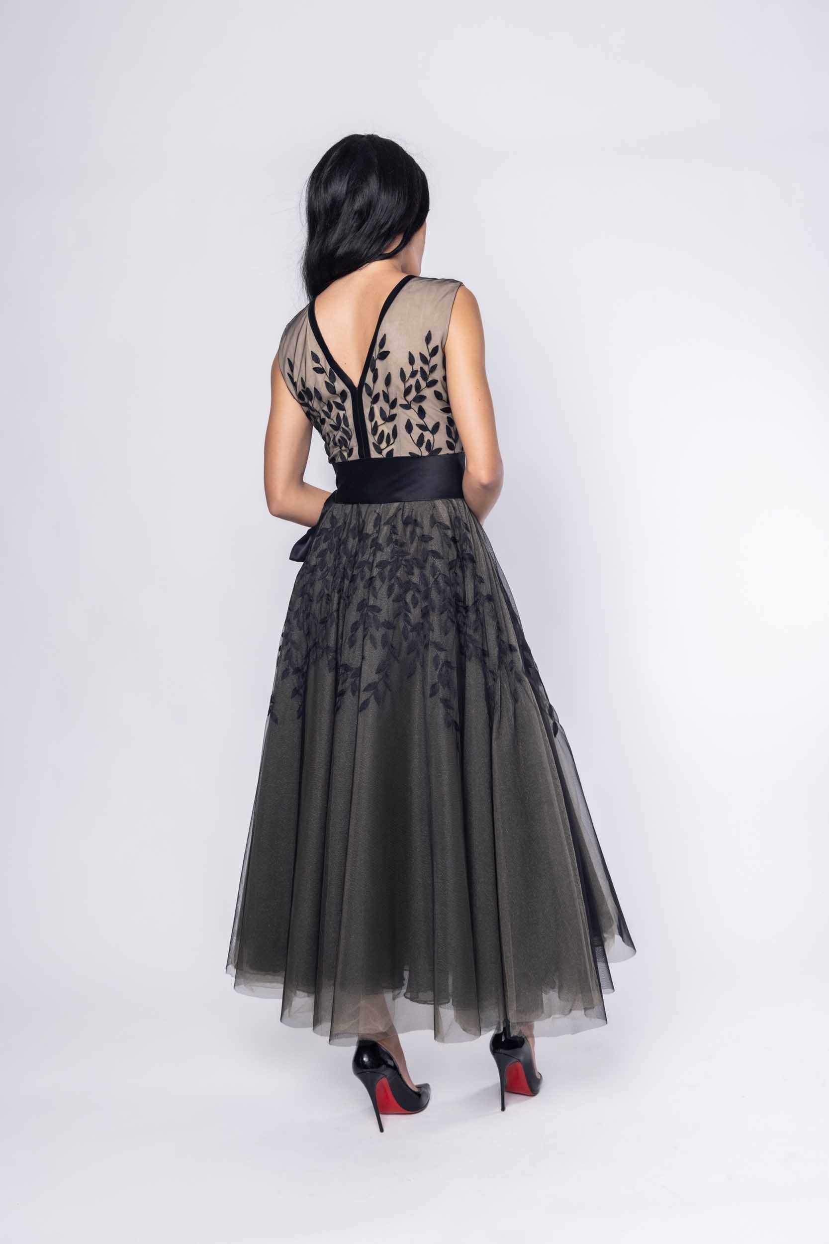 Beautiful model in an ornate black tea-length Sujata Gazder dress - back view