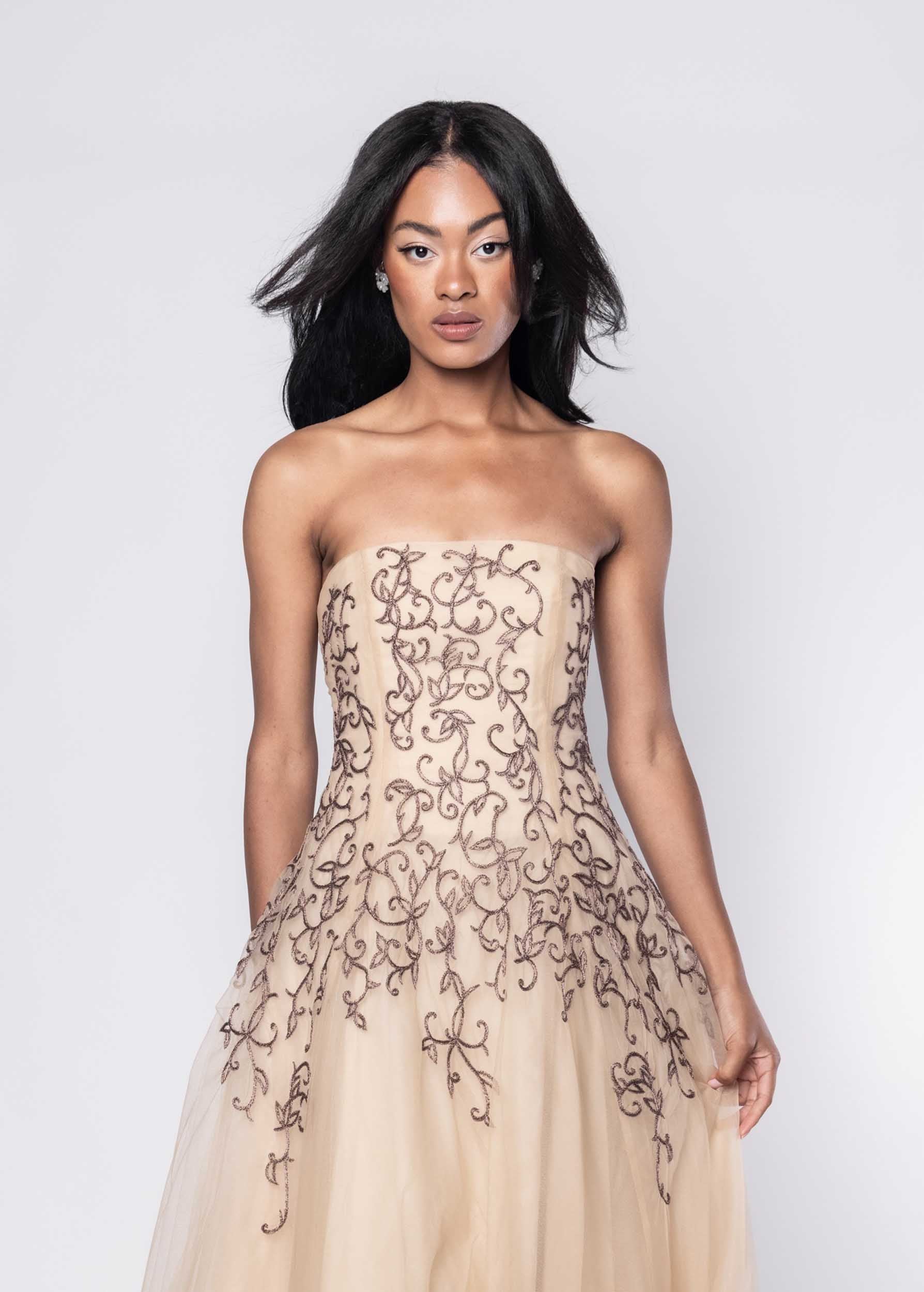 Beautiful model in nude Sujata Gazder cocktail dress with ornate stitching - close view
