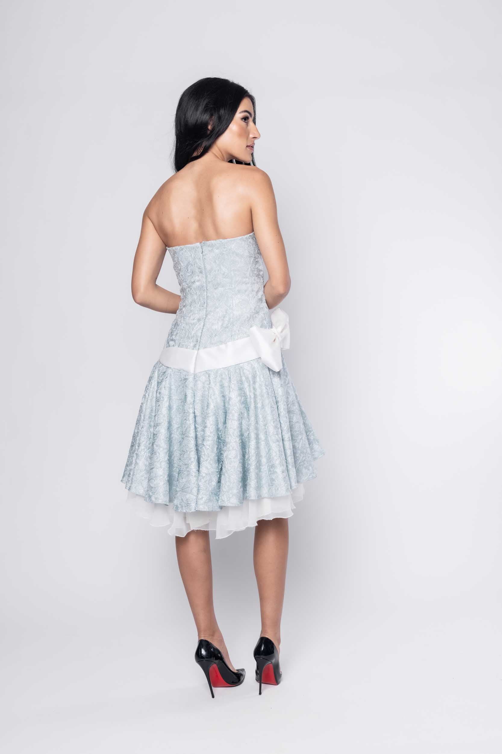 Beautiful model in blue Sujata Gazder cocktail dress with bow - back view