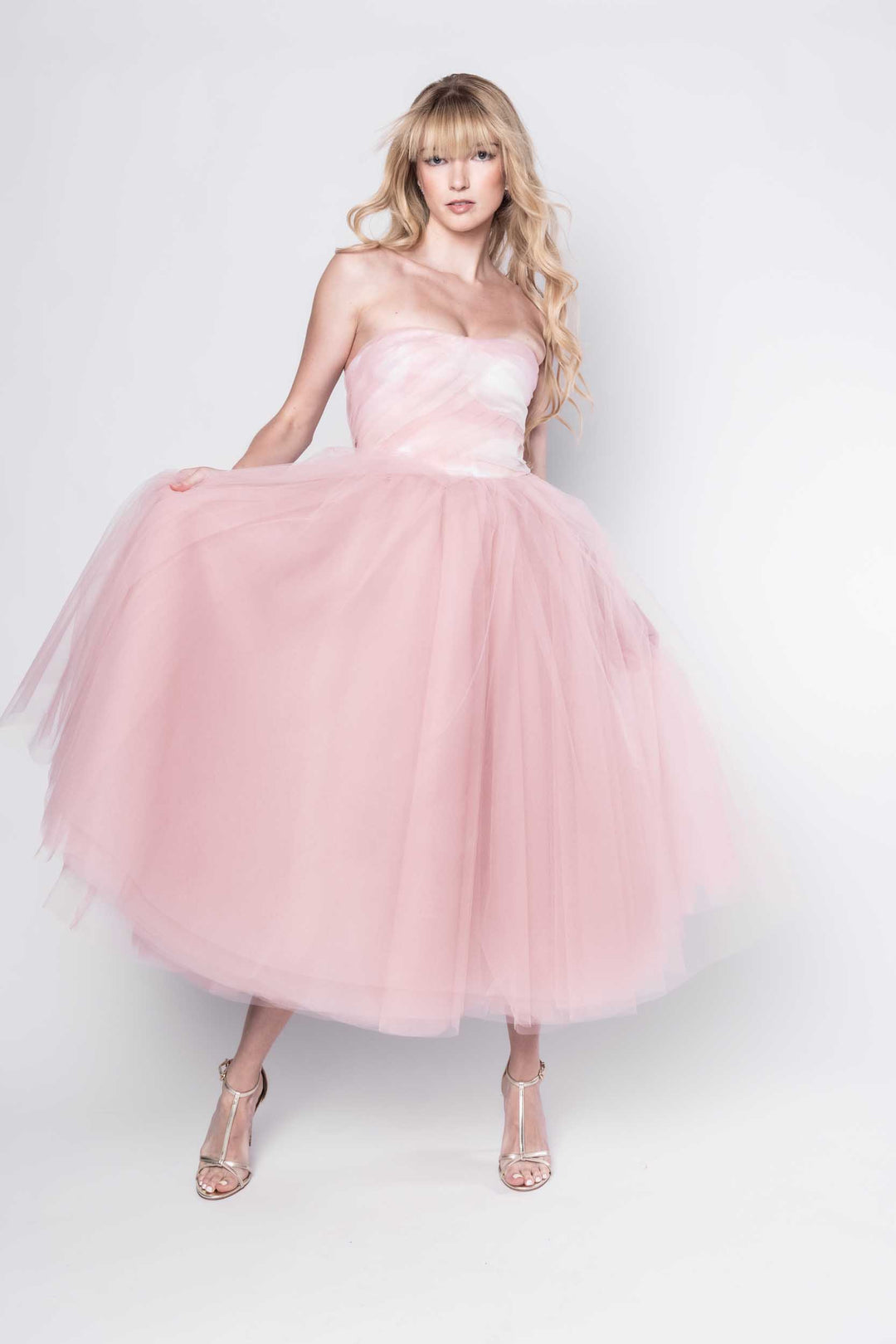 Beautiful model in a pink tulle Sujata Gazder tea-length dress - front view movement