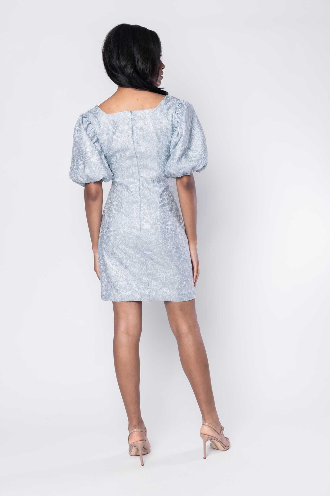 Beautiful model in a pale blue beaded ornate cocktail dress by Sujata Gazder - back view