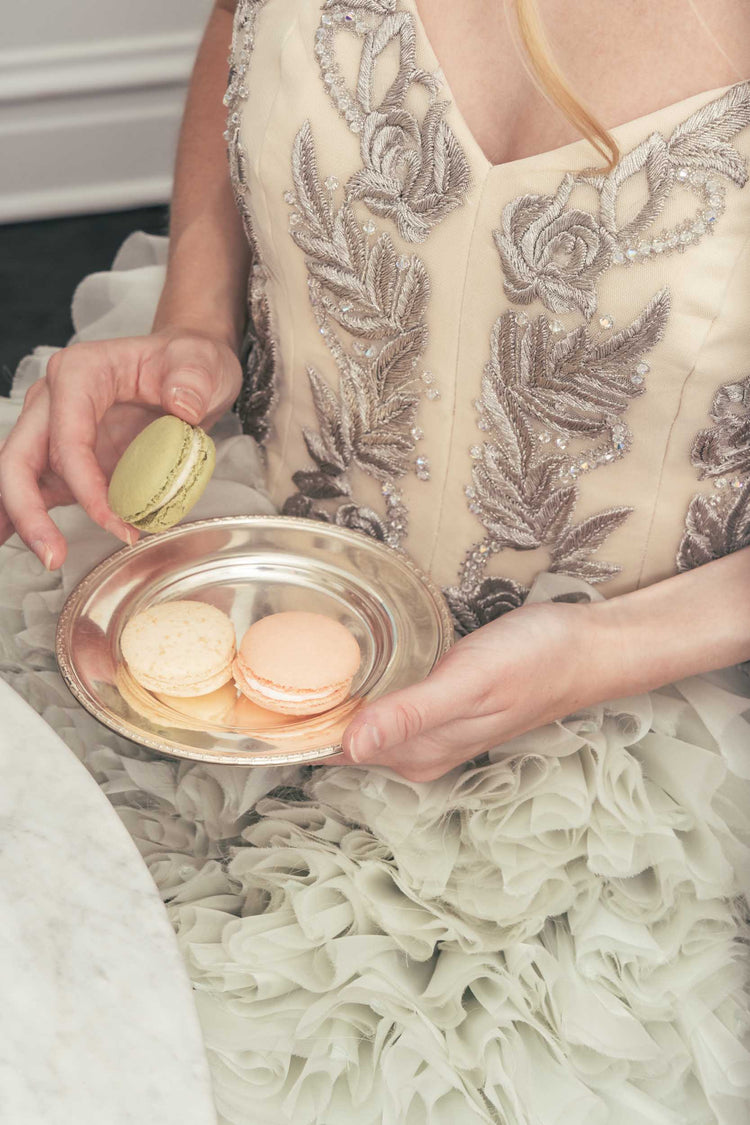 A close shot of frilly pastel Sujata Gazder cocktail dress with a plate of macarons