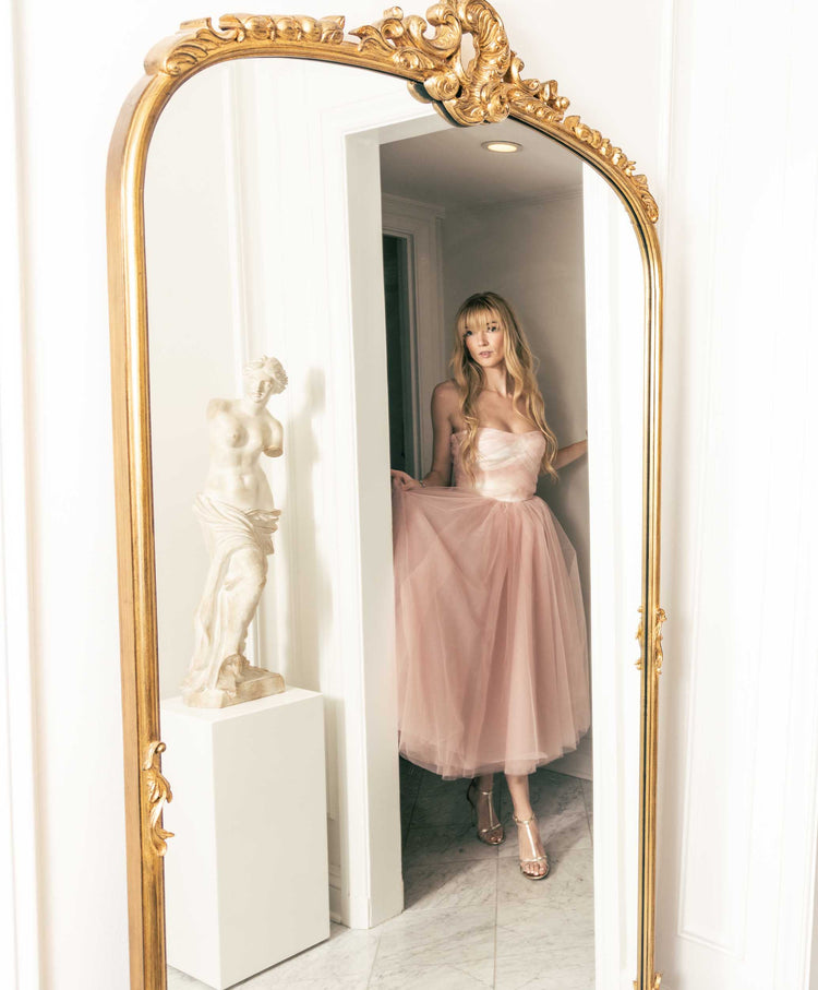 Beautiful model in a chic mirror with statue in a pink tulle Sujata Gazder tea-length dress 